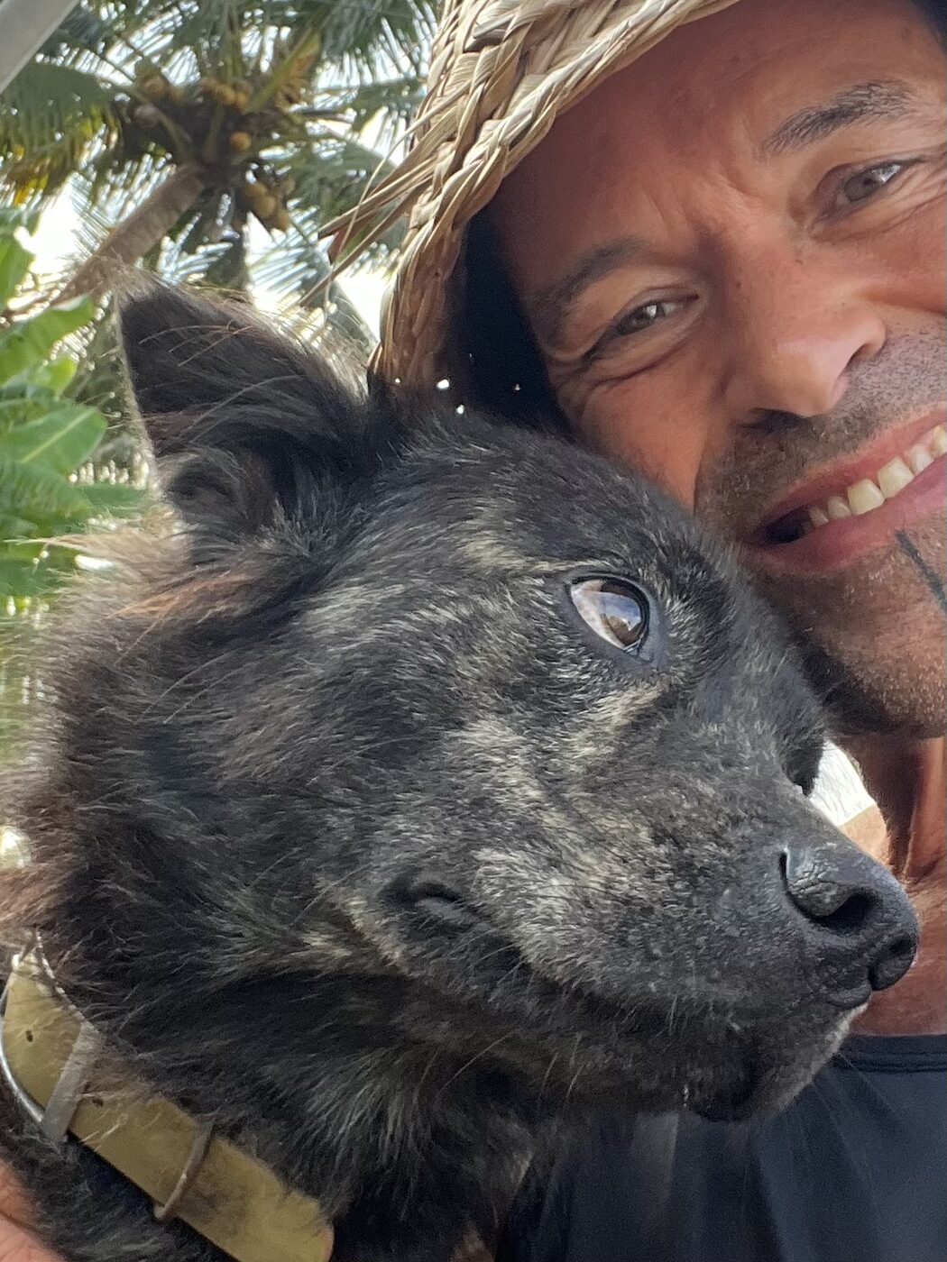 Stephan Mairesse in a straw hat with a brindle dog