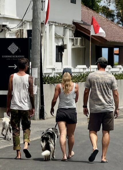 Stephan Mairesse walking with friends and dogs down a street in Bali
